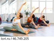 Women performing yoga exercises during group training at gym. Fitness and Hatha yoga concept. Стоковое фото, фотограф Яков Филимонов / Фотобанк Лори