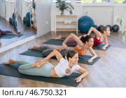 Girl teacher conducts lesson, training for girls in yoga studio and performs ardha bhekasan gym. Стоковое фото, фотограф Яков Филимонов / Фотобанк Лори