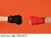 Женские руки в боксерских бинтах на оранжевом фоне. Стоковое фото, фотограф Pixel_shot / Фотобанк Лори