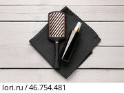 Щетка для волос с распылителем и полотенцем на светлом деревянном фоне. Стоковое фото, фотограф Pixel_shot / Фотобанк Лори