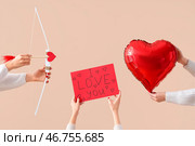 Руки женщины, держащие воздушный шар, знак с надписью С ДНЕМ СВЯТОГО ВАЛЕНТИНА, лук и стрелы Купидона на бежевом фоне. Стоковое фото, фотограф Pixel_shot / Фотобанк Лори