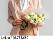 Молодая мусульманка с Кораном и тюльпанами на светлом фоне, крупный план. Празднование Рамадана. Стоковое фото, фотограф Pixel_shot / Фотобанк Лори