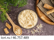 Хреновый соус в миске и ложка с измельченным хреном на сером фоне. Вид сверху. Стоковое фото, фотограф Pixel_shot / Фотобанк Лори