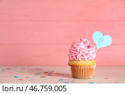 Вкусный кекс с розовым глазурью на столе на цветном фоне. Концепция вечеринки для раскрытия пола ребенка. Стоковое фото, фотограф Pixel_shot / Фотобанк Лори