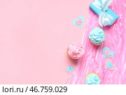 Вкусные кексы с подарочной коробкой и украшениями на розовом фоне. Концепция вечеринки для раскрытия пола ребенка. Стоковое фото, фотограф Pixel_shot / Фотобанк Лори