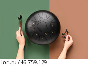 Женские руки с глюкофоном, палочками и нотным листом на цветном фоне. Стоковое фото, фотограф Pixel_shot / Фотобанк Лори