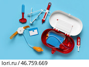 Игрушечная аптечка первой помощи с стетоскопом, термометром и молоточком для проверки рефлексов на синем фоне. Вид сверху. Стоковое фото, фотограф Pixel_shot / Фотобанк Лори