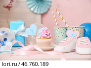 Вкусный кекс с детскими пинетками и украшениями на столе на розовом фоне. Концепция вечеринки по раскрытию пола ребенка. Стоковое фото, фотограф Pixel_shot / Фотобанк Лори
