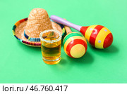Маракасы, декоративная сомбреро и рюмка текилы с солью на зеленом фоне. Стоковое фото, фотограф Pixel_shot / Фотобанк Лори