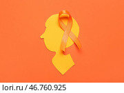 Бумажная человеческая голова и оранжевая лента на цветном фоне. Месяц осведомленности о рассеянном склерозе. Стоковое фото, фотограф Pixel_shot / Фотобанк Лори