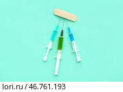 Медицинские шприцы с лекарством с лейкопластырем на бирюзовом фоне. Стоковое фото, фотограф Pixel_shot / Фотобанк Лори