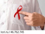 Красивый мусульманин с красной лентой на сером фоне. Концепция осведомленности о СПИДе. Стоковое фото, фотограф Pixel_shot / Фотобанк Лори