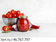 Банка маринованных помидоров с лавровым листом и луком на белом фоне. Стоковое фото, фотограф Pixel_shot / Фотобанк Лори