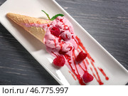 Вафельный рожок с вкусным малиновым мороженым на тарелке. Стоковое фото, фотограф Pixel_shot / Фотобанк Лори