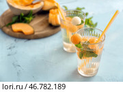 Стакан вкусного коктейля с дынными шариками на светлом столе. Стоковое фото, фотограф Pixel_shot / Фотобанк Лори