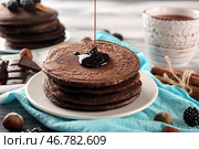 Лить сладкий соус на вкусные шоколадные блины на столе. Стоковое фото, фотограф Pixel_shot / Фотобанк Лори