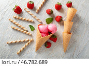 Вафельные рожки с вкусным клубничным мороженым и палочками на деревянном фоне. Стоковое фото, фотограф Pixel_shot / Фотобанк Лори