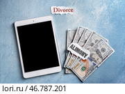 Планшетный компьютер, деньги и документы с текстом ALIMONY и DIVORCE на столе. Стоковое фото, фотограф Pixel_shot / Фотобанк Лори