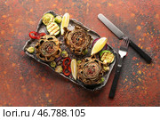 Тарелка с вкусными запеченными артишоками и овощами на столе. Стоковое фото, фотограф Pixel_shot / Фотобанк Лори