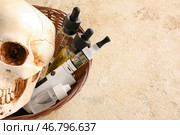 Корзина с вейп-модом, маслом и человеческим черепом на гранж-фоне. Стоковое фото, фотограф Pixel_shot / Фотобанк Лори