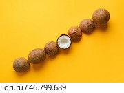 Сломанный кокос среди целых на цветном фоне. Концепция уникальности. Стоковое фото, фотограф Pixel_shot / Фотобанк Лори