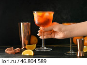 Женщина держит стакан вкусного коктейля aperol spritz на темном фоне, крупным планом. Стоковое фото, фотограф Pixel_shot / Фотобанк Лори