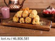 Доска с вкусной пахлавой на деревянном фоне. Стоковое фото, фотограф Pixel_shot / Фотобанк Лори
