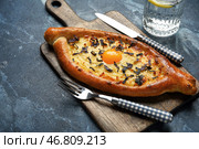 Деревянная доска с вкусными хачапури по-аджарски на цветном фоне. Стоковое фото, фотограф Pixel_shot / Фотобанк Лори