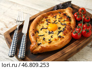 Доска с вкусными хачапури по-аджарски на светлом деревянном фоне. Стоковое фото, фотограф Pixel_shot / Фотобанк Лори