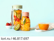 Спортивные бутылки с водой с добавлением различных нарезанных фруктов на синем фоне. Стоковое фото, фотограф Pixel_shot / Фотобанк Лори