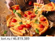 Женщины берут кусочки вкусной пиццы маргарита на деревянном столе. Стоковое фото, фотограф Pixel_shot / Фотобанк Лори