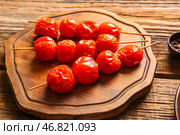 Доска со шпажками с вкусными жареными помидорами на деревянном фоне. Стоковое фото, фотограф Pixel_shot / Фотобанк Лори