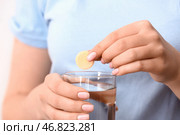 Женщина опускает растворимую таблетку в стакан воды, крупным планом. Стоковое фото, фотограф Pixel_shot / Фотобанк Лори