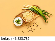 Миска вкусной сметаны с нарезанным зеленым луком и картофельными чипсами на оранжевом фоне. Стоковое фото, фотограф Pixel_shot / Фотобанк Лори