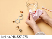 Женщина полирует красивое кольцо на цветном фоне, крупным планом. Стоковое фото, фотограф Pixel_shot / Фотобанк Лори