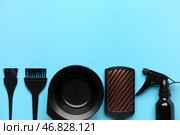 Расчески парикмахера с распылителем и чашей на голубом фоне. Стоковое фото, фотограф Pixel_shot / Фотобанк Лори
