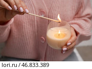 Женщина с спичкой зажигает свечу, крупным планом. Стоковое фото, фотограф Pixel_shot / Фотобанк Лори