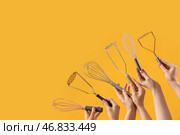 Женские руки, держащие разные венчики и толкушки на желтом фоне. Стоковое фото, фотограф Pixel_shot / Фотобанк Лори