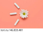 Композиция с менструальными тампонами и ромашковым цветком на коралловом фоне. Стоковое фото, фотограф Pixel_shot / Фотобанк Лори