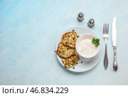 Тарелка вкусных кабачковых оладий с сметаной на светлом фоне. Стоковое фото, фотограф Pixel_shot / Фотобанк Лори