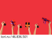Женщины с подарками на Хэллоуин и котлами на красном фоне. Стоковое фото, фотограф Pixel_shot / Фотобанк Лори