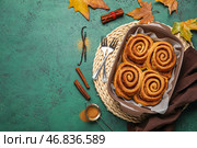 Форма для выпечки вкусных корицевых булочек и осенние листья на зеленом фоне. Стоковое фото, фотограф Pixel_shot / Фотобанк Лори
