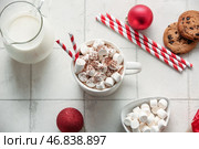 Чашка горячего какао с маршмеллоу, рождественскими шариками и сладкими печеньями на белом плиточном фоне. Стоковое фото, фотограф Pixel_shot / Фотобанк Лори