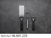 Тёрка, венчик и овощечистка на темном фоне. Стоковое фото, фотограф Pixel_shot / Фотобанк Лори