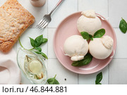 Тарелка вкусного сыра Буррата с базиликом и маслом на белом плиточном фоне. Стоковое фото, фотограф Pixel_shot / Фотобанк Лори