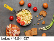 Жареная сковородка с вкусными яичницей с помидорами и беконом на сером фоне. Стоковое фото, фотограф Pixel_shot / Фотобанк Лори