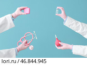 Руки женского доктора с различными медицинскими инструментами на голубом фоне. Стоковое фото, фотограф Pixel_shot / Фотобанк Лори