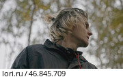 Man wanders in forest and looks around anxiously. Stock. Young man walks in woods with phone and looks around anxiously. Man is lost in woods with phone and looks around in fear. Стоковое фото, фотограф Данил Руденко / Фотобанк Лори