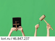 Женские руки с Библией, крестом, молотком и гвоздем на зеленом фоне. Концепция Страстной пятницы. Стоковое фото, фотограф Pixel_shot / Фотобанк Лори