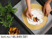 Женщина готовит вкусную галету из сливы на черном столе. Стоковое фото, фотограф Pixel_shot / Фотобанк Лори